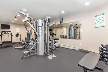 A gym with a variety of equipment including a leg press machine.